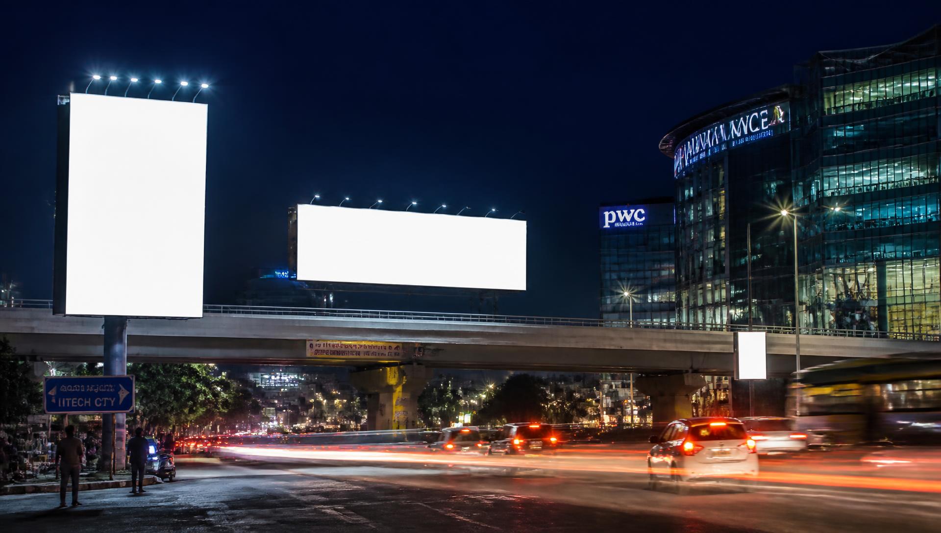 Large outdoor hoarding overlooking a busy Indian city road at dusk